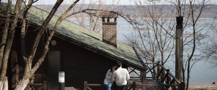 Ett par som sitter utanför sitt fritidshus vid en sjö