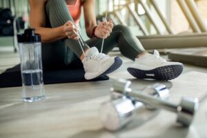 Kvinna knyter skor på gym