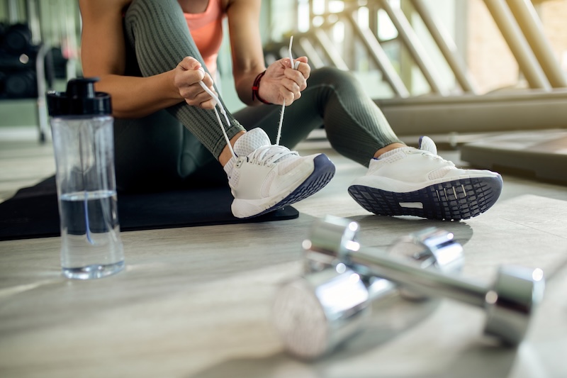 Kvinna knyter skor på gym
